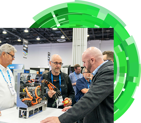 Two men standing side by side, engaged in conversation at a bustling trade show event